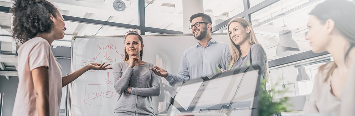 Co-workers standing in front of a whiteboard