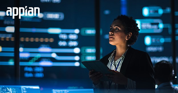 Women standing in a control room looking at a tablet