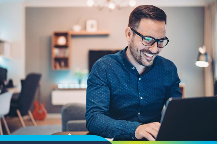 Man smiling working at laptop