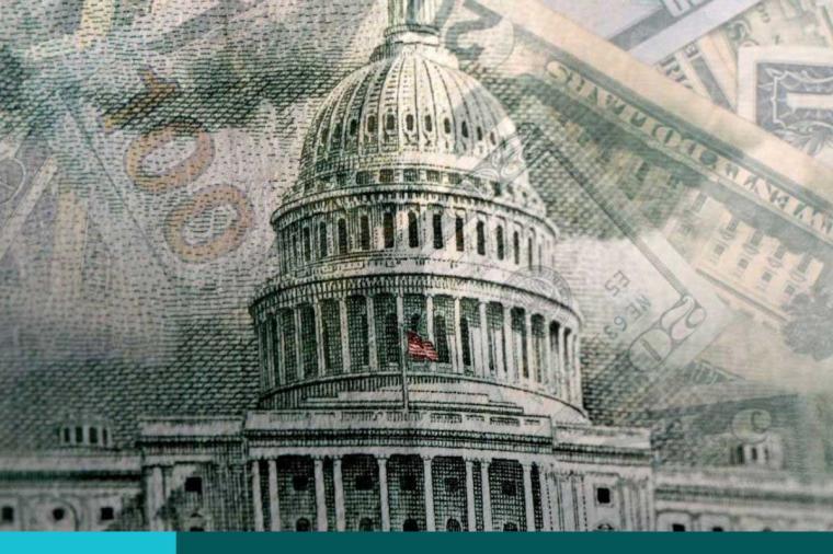 U.S currency bills superimposed over the Capitol