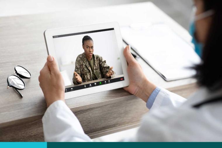 Woman in fatigues doing a telehealth meeting with her doctor
