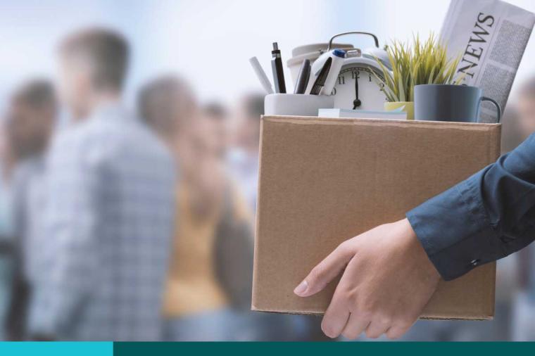 Woman carrying her office belongings out in a box