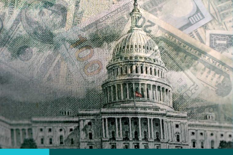 Pieces of currency in the background of the U.S. Capital