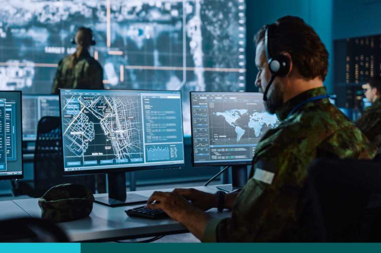 Military Surveillance Officer Working on a City Tracking Operation in a Central Office Hub for Cyber Control and Monitoring for Managing National Security, Technology and Army Communications.