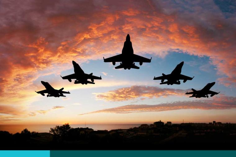 Five fighters flying at sunset