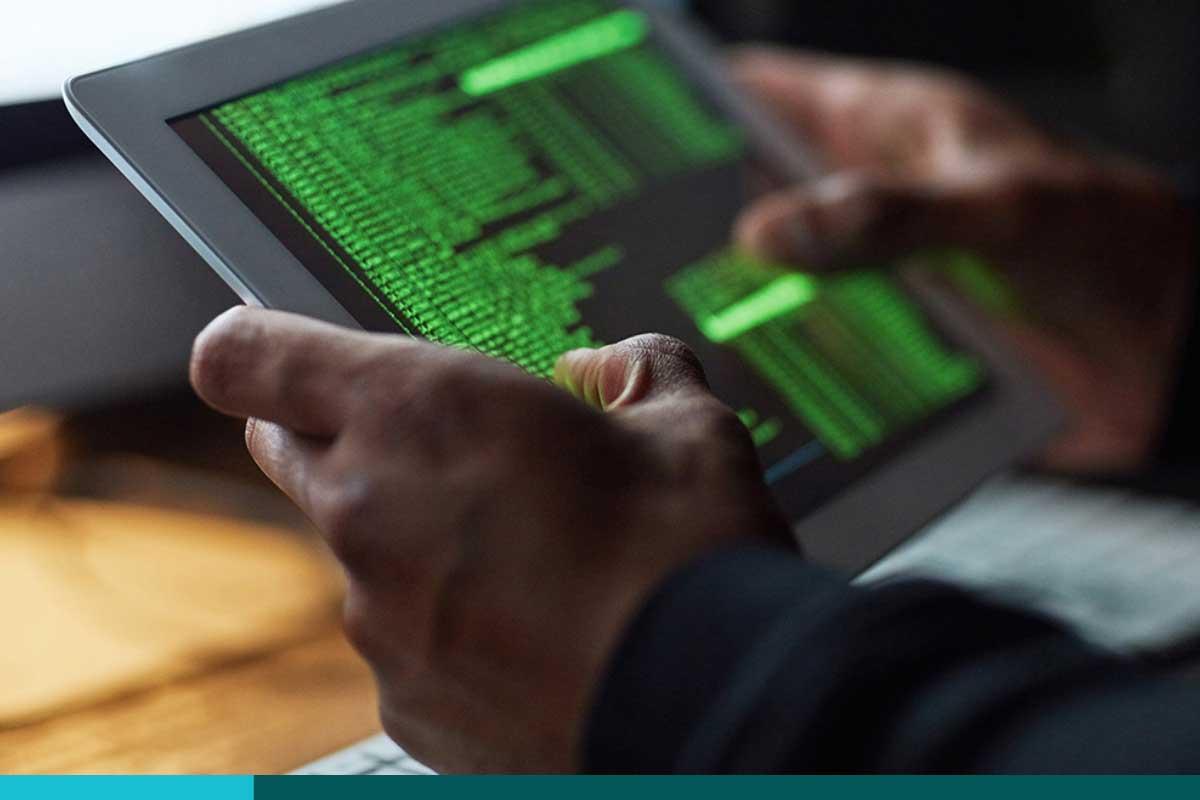 Man holding a tablet with lines of code written in green