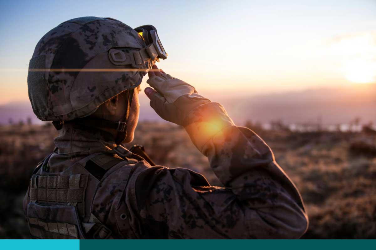 Female Army Solider Saluting against sunset sky.